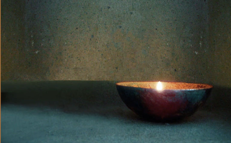 Espelma encesa dins un bol per fer pràctica de meditació
