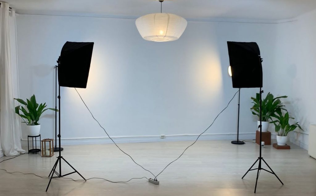 Sala diáfana con focos profesionales para iluminación preparada para una sesión de grabación.