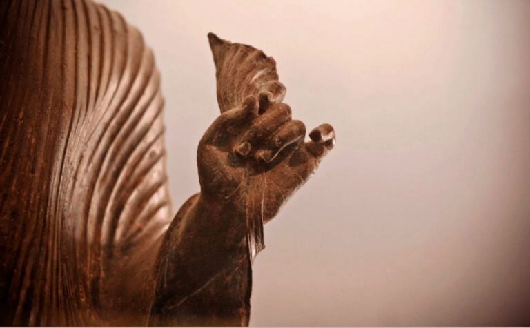 Bronze statue representing Buddha making a mudra during a meditation practice.