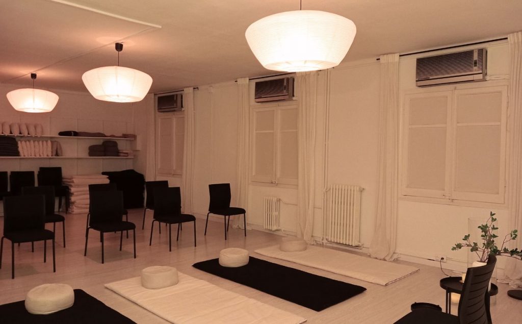 Gran espacio con sillas y futones preparados para hacer una clase de meditación y mindfulness.