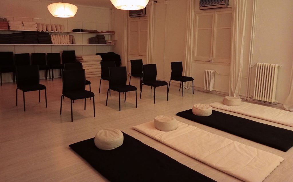 Interior de una escuela de meditación con iluminación agradable y tenue, lista para ofrecer una clase grupal de mindfulness.