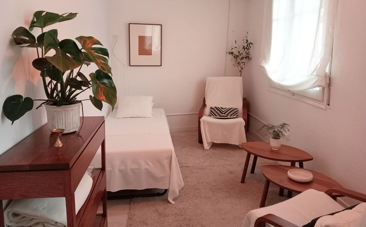 Sala de terapias preparada para hacer prácticas de relajación profunda, con un diván y dos sillones
