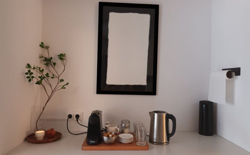 Pequeña cocina-office con vasos y tazas para beber agua antes o después de una clase de meditación.